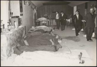 A small group of men identifying the bodies of victims in the aftermath of an earthquake in Tuscany killed 31 people, and left about 5,000 homeless