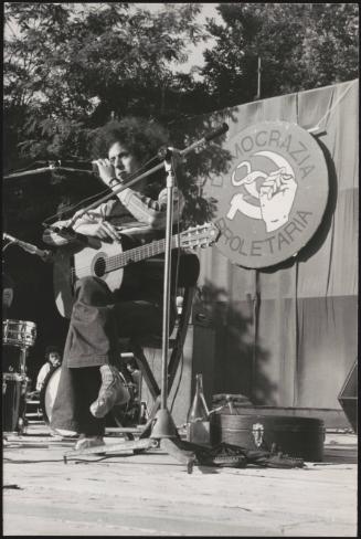 Folk rock singer Angelo Branduardi performs on an outdoor stage at a proletarian democracy event