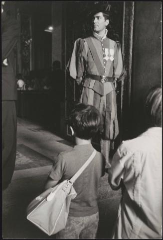 A boy and his mother arriving at the Vatican City, Swiss Guard standing at the door