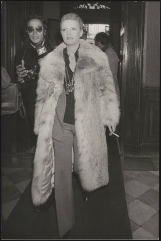 Singer Patty Pravo in a fur coat, walks through a foyer 