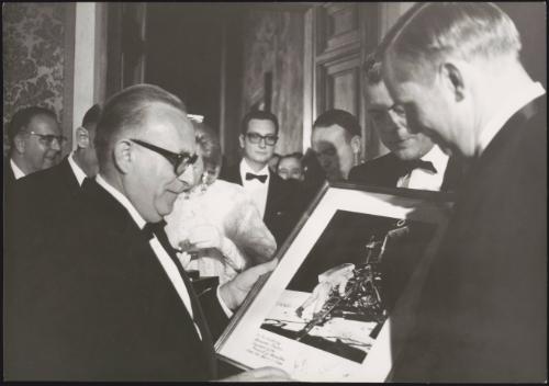 The astronauts from Apollo 11, Neil Armstrong, Michael Collins and Buzz Aldrin being presented with a framed photo of their landing on the moon 