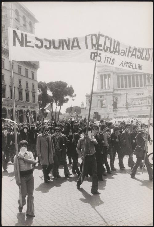 A group marching with bandanas over their faces, at an anti-Fascist demonstration near St. Peter's Square in Rome