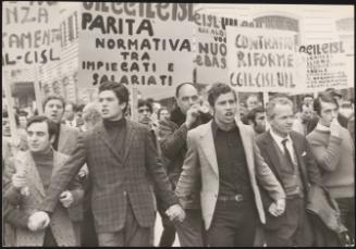 A group of men, part of the labour trade unions, link hands and lead a protest for contract reforms