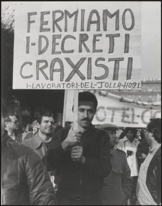 A man holds up his protest placard at a workers' demonstration protesting against socialist politician Bettino Craxi