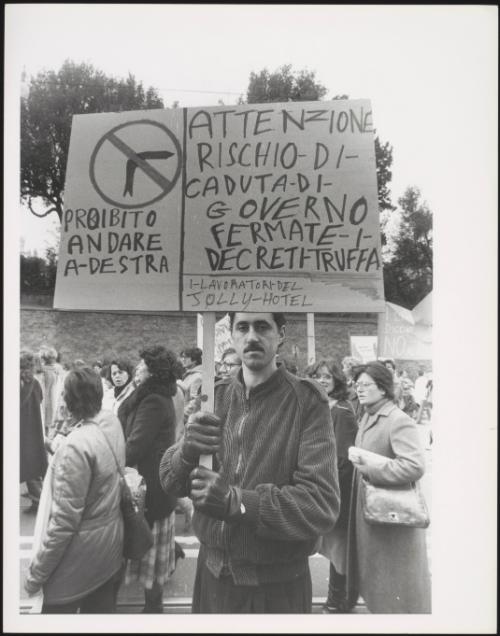 A man holds up his protest placard at a workers' demonstration protesting against politician Bettino Craxi