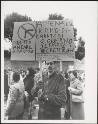 A man holds up his protest placard at a workers' demonstration protesting against politician Bettino Craxi