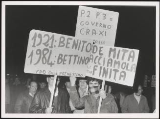 Protesters hold up placards against Italian politician Bettino Craxi, comparing him to dictator Benito Mussolini, and accusing him of involvement in the Masonic Lodge 'P2'