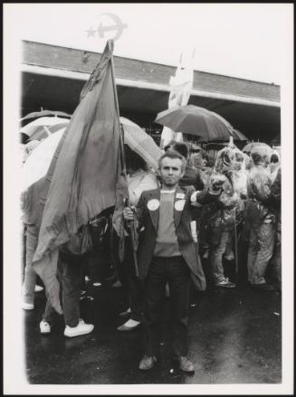 Protesters with flags and umbrellas in the rain