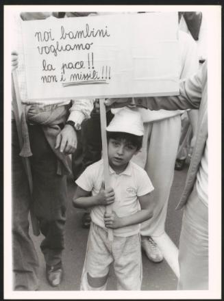 A child holding a banner calling for peace against the nuclear missiles