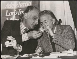 Marco Pannella and Loris Fortuna share a cigarette light at a pro Divorce talk