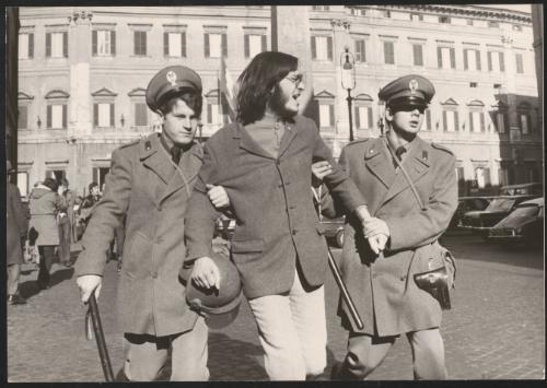 A protester escorted away by policemen