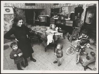 Mother and three young children in family living room, Naples