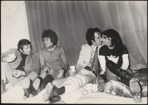 Young couples picnicking on cushions in a tent