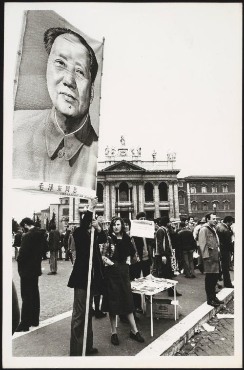 An unspecified protest in a public square with a large poster of Chairman Mao