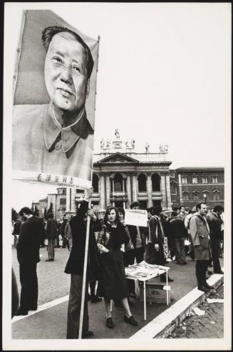 An unspecified protest in a public square with a large poster of Chairman Mao