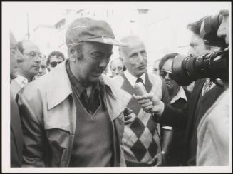 A man gets emotional as he is interviewed by a camera crew about the Great Synagogue of Rome attack