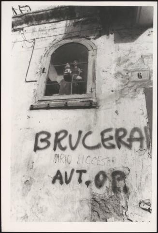 Graffiti on the wall below a window on buildings in the abandoned city of Matera, Italy