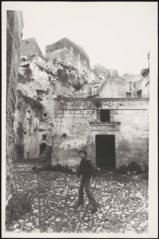 A young boy stands in a courtyard in the abandoned city of Matera