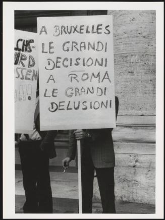 A demonstrator holds a placard