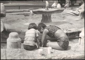 Summer Holiday; a mother and child at a fountain