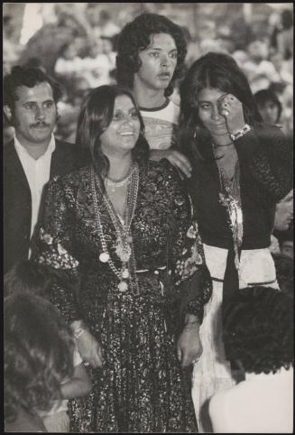 Romani women, flanked by two men and two children