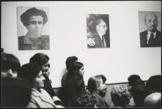 PCI members under portraits of Gramsci and Lenin at a meeting in the Tor de Schiavi district, Rome