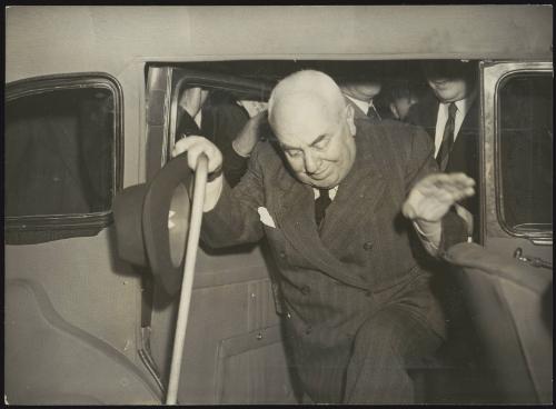 Former Prime Minister of Italy, Francesco Saverio Nitti, exiting a car holding a walking stick and hat