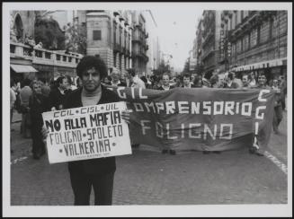 At a trade union protest, a man holds up a 'No to the Mafia' placard