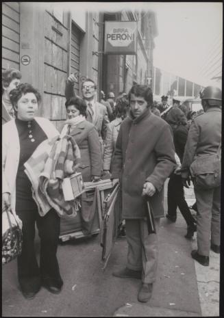 A crowd of evicted squatters are moved on by the police
