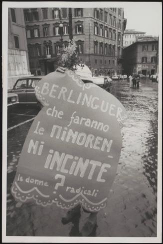 A member of the Radical party carries a protest placard that criticises the politician Enrico Berlinguer's approach to the abortion law