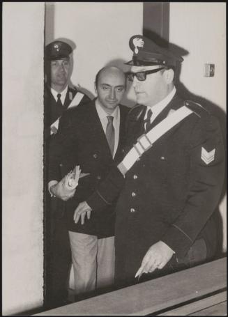 The murderer Marino Vulcano being led into the dock by police