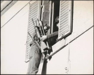 Soldiers climbing out of a window having collected weapons from inside
