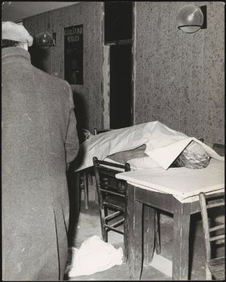 A man looks at a victim laid under a sheet in the aftermath of an earthquake, 1976