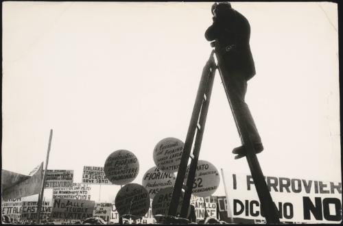 A journalist on a ladder takes a photo of a demonstration against unemployment, unfair dismissal of jobs and pro-school reform