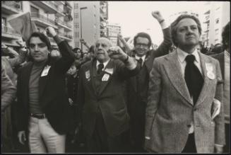 Portuguese politician Mário Soares, marches with crowds through the street. 