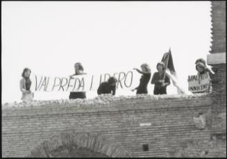 Five people protesting on the roof of a building against the unexplained death of Pino Pinelli and the incarceration of Peter Valpreda, accused of The Piazza Fontana bombings