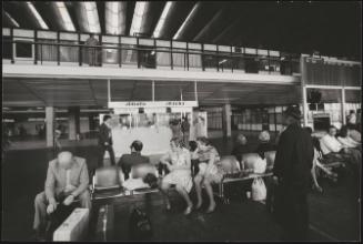 Passengers waiting for a flight near the check-in booths for Alitalia