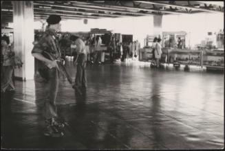 An armed guard overlooks an airport foyer 