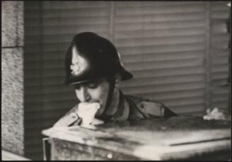 A firefighter moving a large chest out of a building damaged by the Belice earthquake, Sicily 1968