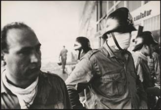 A firefighter with a makeshift mask outside a building damaged after the Belice earthquake, Sicily 1968