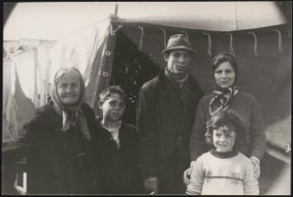 A family stand in front of temporary shelter in the aftermath of the Belice earthquake in Sicily 1968