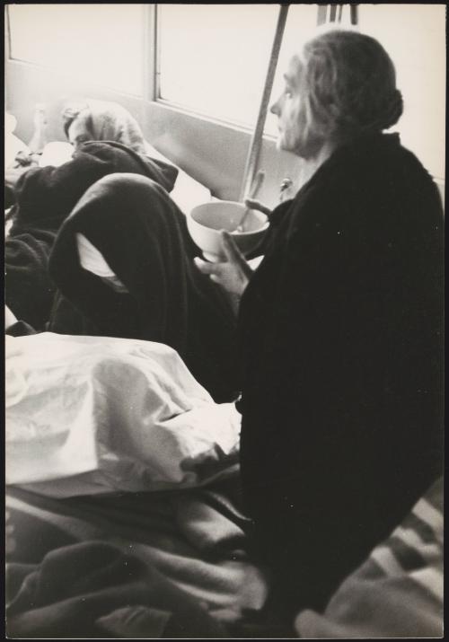 A woman eats a bowl of soup in temporary shelter in the aftermath of the Belice earthquake, Sicily 1968