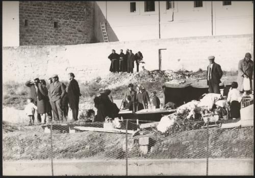 On the outskirts of town, watched over by members of the church, refugees set up temporary accommodation camps in the aftermath of the Belice earthquake in Sicily 1968