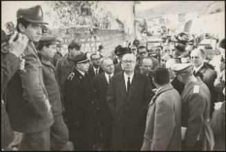 President of the Republic Giuseppe Saragat and interior minister Paolo Emilio Taviani walk with other officials, uniformed police and displaced residents in Sicily after the Belice earthquake, 1968
