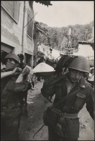 Soldiers carry out a body of a victim from a building damaged by the Friuli earthquake, 1976