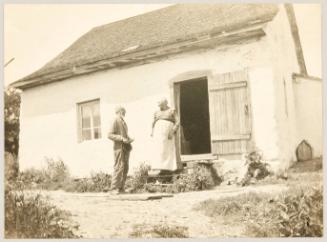 Man and woman talking on steps of old home in Quebec