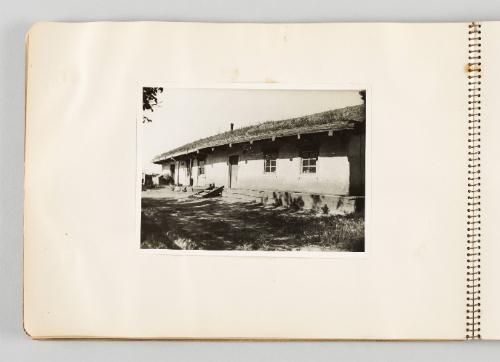 [Front of one-story building with shadows of tree branches, page 12 of The Doukhobors I album]