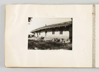 [Front of one-story building with shadows of tree branches, page 12 of The Doukhobors I album]