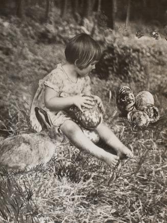 Girl, rabbit and large eggs in the grass