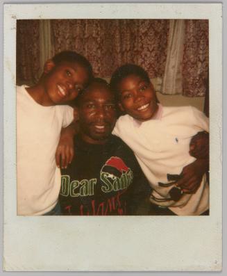 [Two kids posing with man in the middle]
